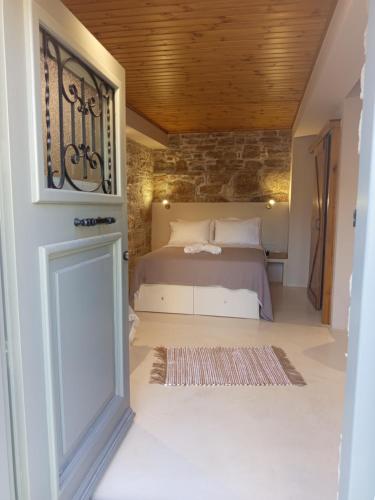 a bedroom with a bed and a stone wall at cozystudio Chezmoi in Chios