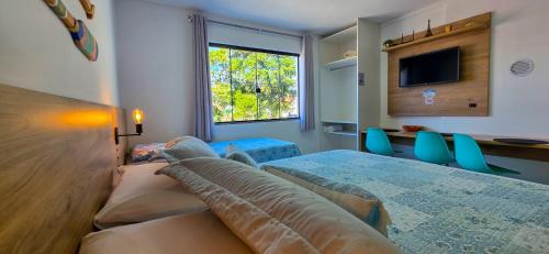 a bedroom with a bed and a table and chairs at Águas de Canto Grande in Bombinhas