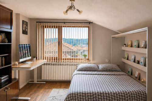 a bedroom with a bed and a large window at Mountain View Apartment in Troyan