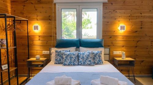 a bedroom with a bed with blue and white pillows at Divine Studios A1 in Elafonisos