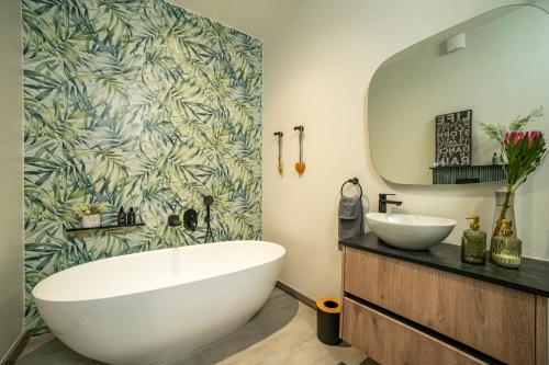 a bathroom with a large white tub and a mirror at Fifty Ridge in George