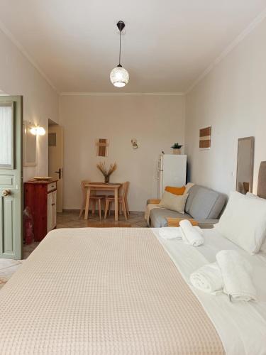 a bedroom with a large bed and a living room at Feidiou 1, vol I in Egina