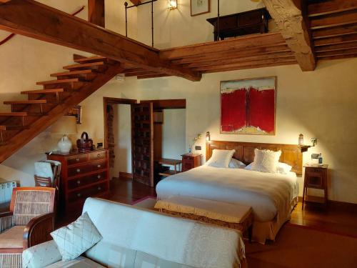 a bedroom with a large bed and a staircase at Hotel Rural Palacio de Prelo in Boal