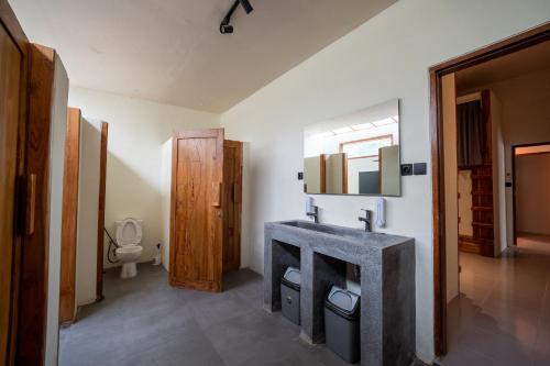 a bathroom with a sink and a toilet at The Purple Pineapple Beach Hostel in Kuta Lombok