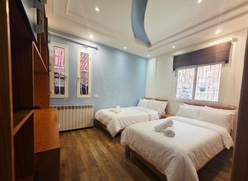 a bedroom with two beds and a blue wall at New Halat, Linda in Jbeil