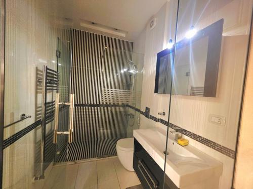 a bathroom with a shower and a toilet and a sink at New Halat, Linda in Jbeil