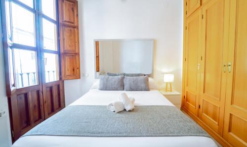 a bedroom with a large bed with a towel on it at Bonito y acogedor apartamento pleno centro junto Catedral in Granada