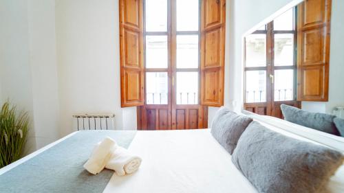 a bedroom with a bed with a towel on it at Bonito y acogedor apartamento pleno centro junto Catedral in Granada