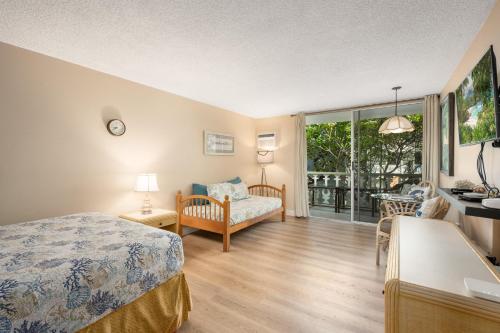a bedroom with a bed and a living room at Kona Islander Inn#228: Located in downtown Kona! in Kailua-Kona