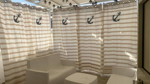 a shower curtain with a pair of shoes on it at Casa Indaterr in Mola di Bari