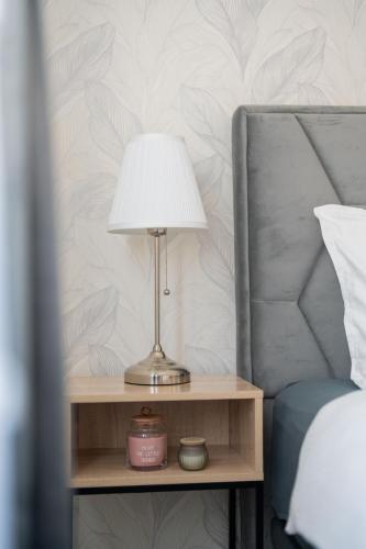 a lamp on a night stand next to a bed at Apartman Nika-Self check-in,Free Parking in Vukovar