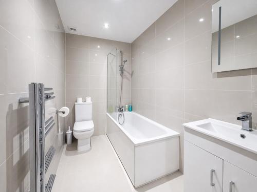 a white bathroom with a toilet and a sink at Relax in a Spacious 2-Bed Pinner Hideaway in Northwood