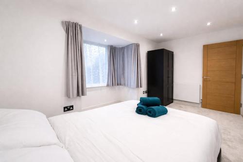 a bedroom with a large white bed with a blue elephant on it at Relax in a Spacious 2-Bed Pinner Hideaway in Northwood
