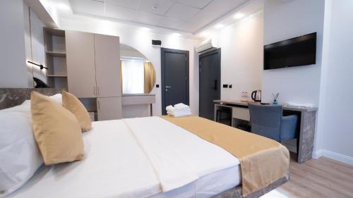 a bedroom with a large white bed and a desk at Kıyı Hotel Restaurant in Gebze