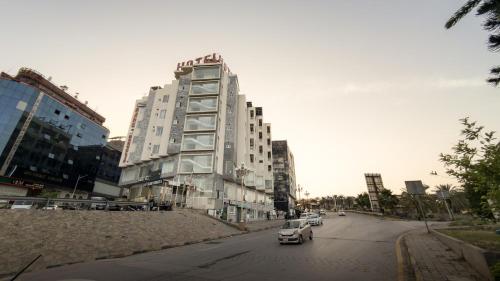 a car driving down a city street with tall buildings at Grand Mongolia in Rawalpindi