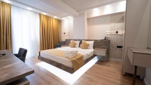 a hotel room with a bed and a desk and a table at Kıyı Hotel Restaurant in Gebze