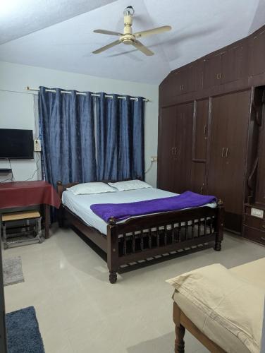 a bedroom with a bed and a ceiling fan at Coorg homes in Madikeri