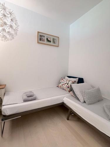 a couch sitting in a room with white walls at Holiday on The Lake Lugano 2 in Bissone