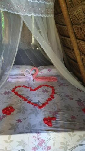 a heart made out of red roses on a bed at Cabana Jamelão in Camaçari