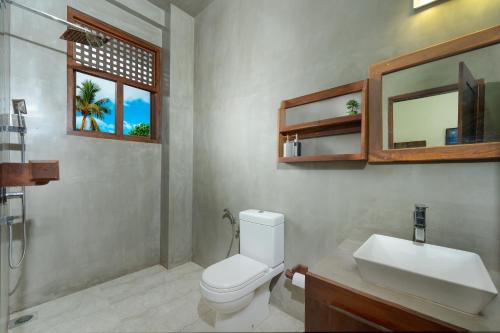 a bathroom with a toilet and a sink and a mirror at Luminara Sky Lounge with Pool near Ahangama Beach in Ahangama