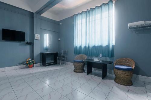 a room with a table and chairs and a television at Hotel O SPRINGVILLA in Dispur