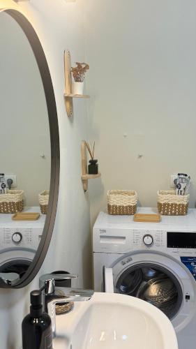 a bathroom with a washing machine and a mirror at The Nook Apartment in Jesenice