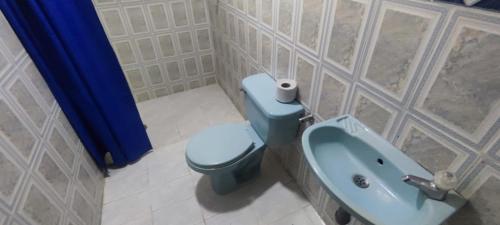 a bathroom with a blue toilet and a sink at Oasis in Valledupar