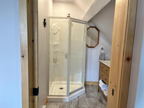 a shower with a glass door in a bathroom at Seaside Beach Resort in Saint Andrews