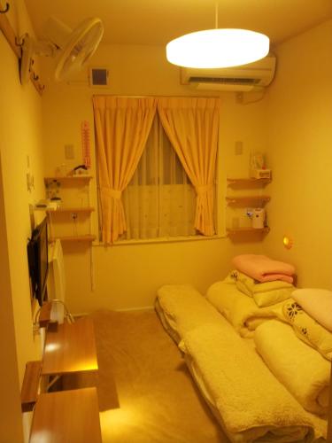 two beds in a room with a window at Tokyo8home Hachioji in Hachioji
