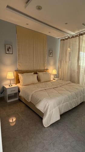 a bedroom with a large white bed with two lamps at شقة ريفالا الفاخرة in Abha