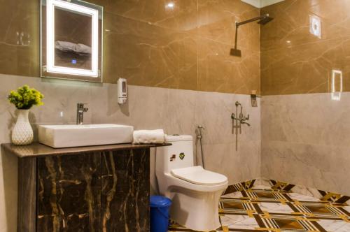 a bathroom with a sink and a toilet at Earavat Resort in Rāmnagar