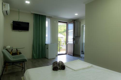 a bedroom with a bed with a pair of shoes on it at Spitak tun in Ijevan