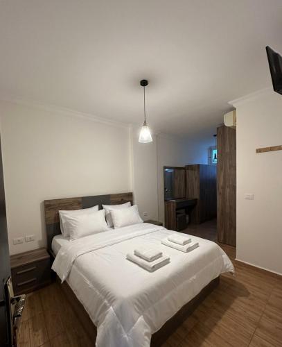 a bedroom with a large white bed with two towels on it at Berbara, Chadi in Dayr Jannīn