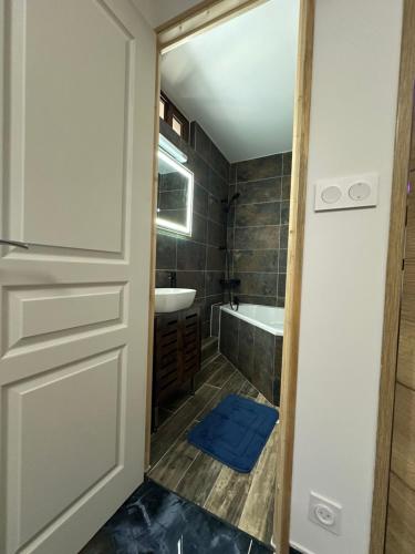 a bathroom with a door and a tub and a sink at Ó maestro home in Avignon