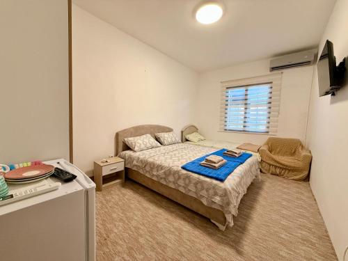 a small bedroom with a bed and a window at Sobe Baosici Marina in Herceg-Novi