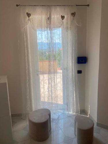 a living room with a large window and two stools at Surripe Casa Vacanze in San Lorenzello