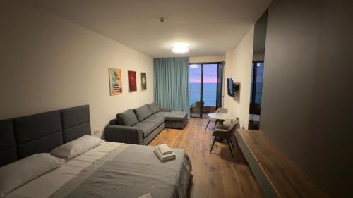 a hotel room with a bed and a couch at Go Bamboo Beach Apartments in Ts'ikhisdziri