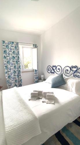a large white bed with two towels on it at Casa do Portão Azul - Tamboril in Atouguia da Baleia
