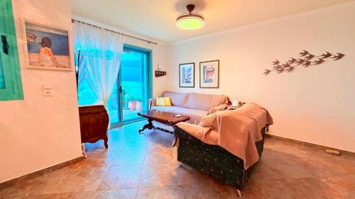 a living room with a couch and a table at Aurora Maris Maisonette in Possidi