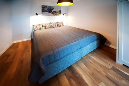 Łóżko w pokoju z drewnianą podłogą w obiekcie Very Berry - K Jadwigi 58 - Old City Apartment, self check in 24h! w Poznaniu