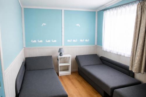 a living room with two couches and a window at Domki Bliźniak in Ustka