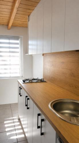 a kitchen with white cabinets and a sink at Domki Bliźniak in Ustka