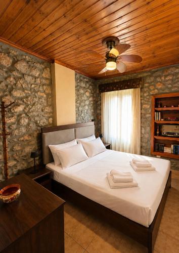 a bedroom with a bed with a wooden ceiling at Stone house Amfikleia in Amfikleia