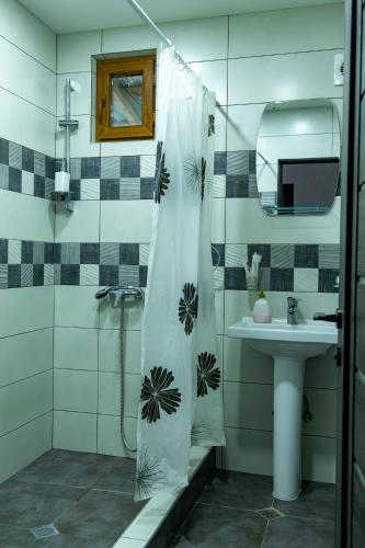 a bathroom with a shower curtain and a sink at Spitak Tun in Ijevan