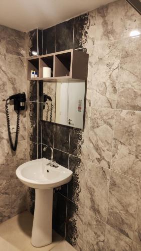 a bathroom with a sink and a phone at Tut Hotel in Antalya