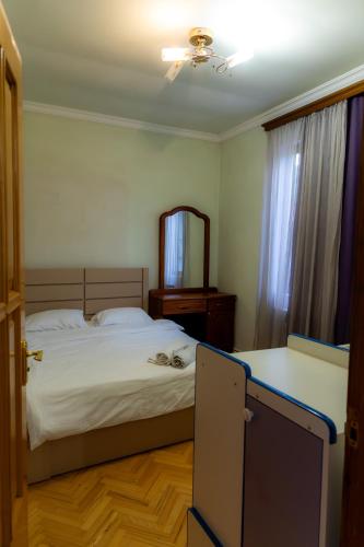 a bedroom with a bed and a dresser and a mirror at Spitak Tun in Ijevan