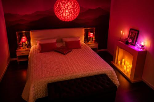 a bedroom with a bed with red lighting and candles at BLOM Spa privatif près de Douai, salle de massage, petit-déjeuner inclus in Guesnain