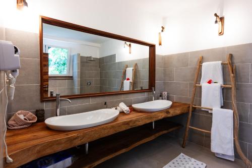a bathroom with two sinks and a large mirror at Reve Island Lodge in Grand Anse