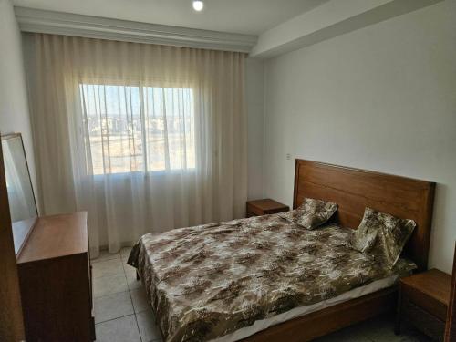 a bedroom with a bed and a large window at Appartement 3 chambres bien situé à Mrezga in Hammamet Nord
