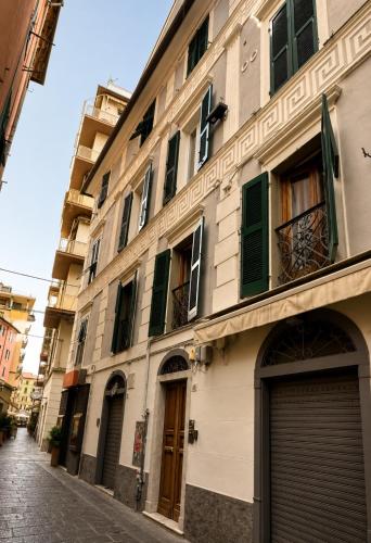 a building with green doors and windows on a street at Cinque Terre Sweet Home - Centro La Spezia - 5 min stazione - Ideale Cinque Terre - WiFi e AC in La Spezia
